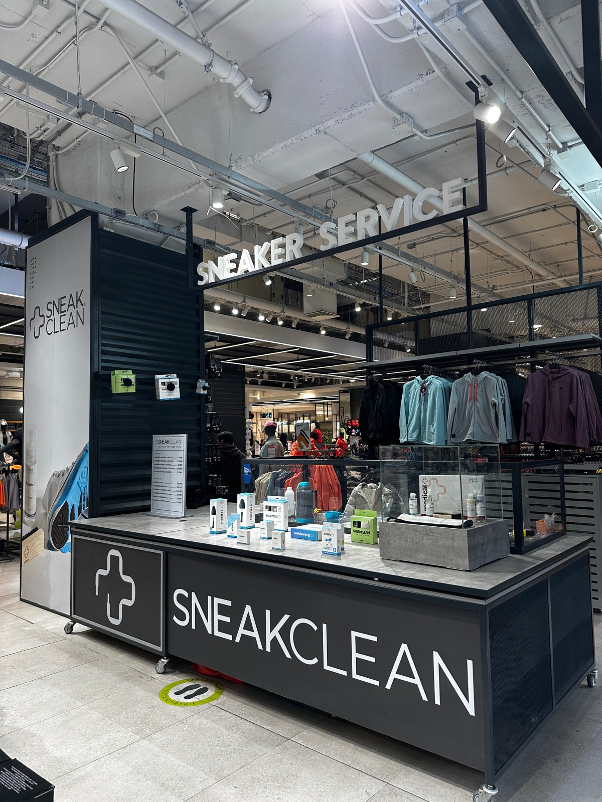 Pop-up SneakClean en Falabella Parque Arauco: mesón negro con el logo, productos en exhibición y letrero Sneaker Service