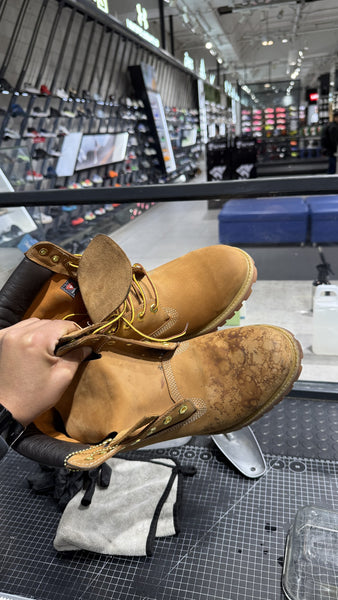 Par de Timberland en el taller SneakClean: el bototo de atrás ya lavado y el de adelante todavía con las manchas de agua y sal